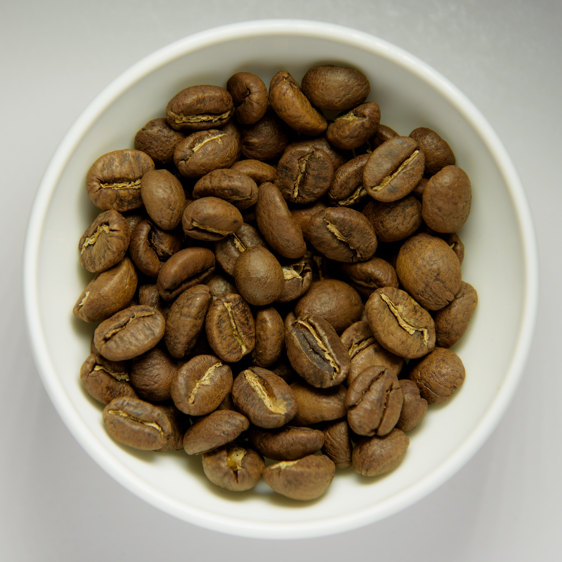 Granos de café tostado en un tazón blanco